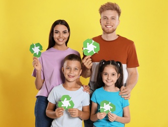 Photo of Young family with recycling symbols on yellow background
