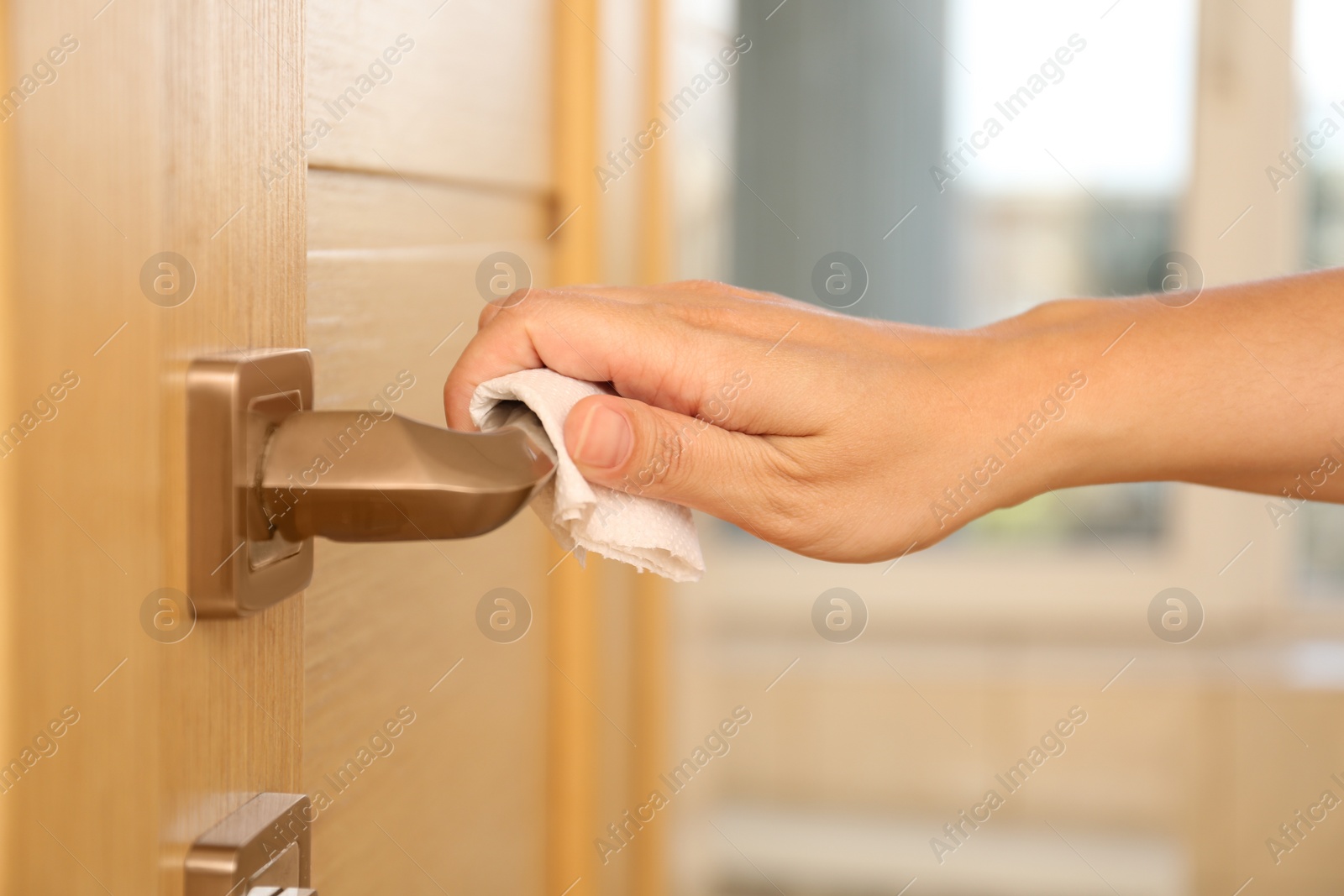 Photo of Woman using tissue paper to open door, closeup