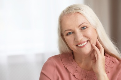 Portrait of beautiful older woman against blurred background with space for text