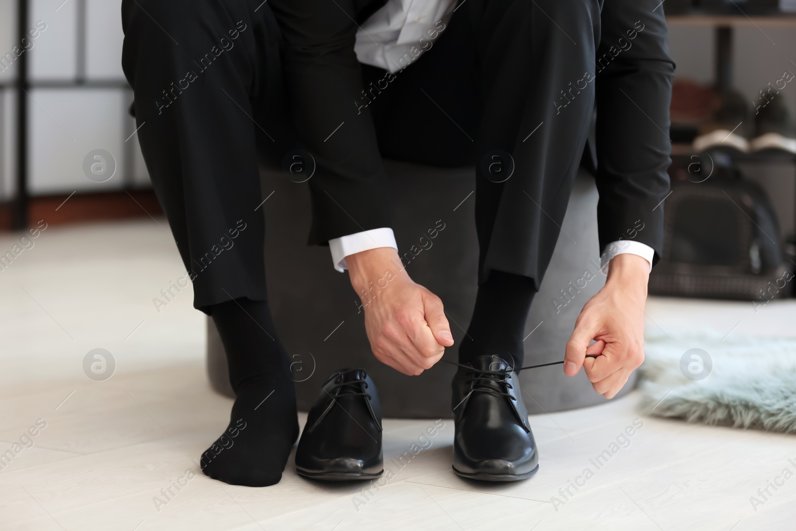 Photo of Young man trying on shoes in store