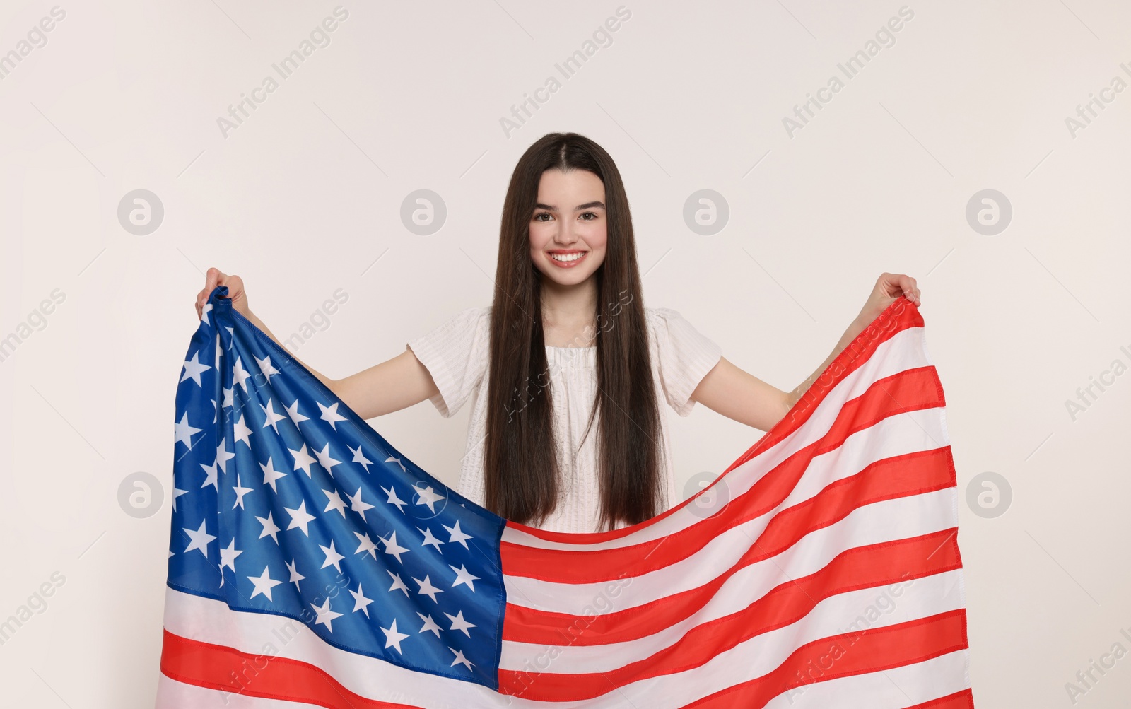 Photo of 4th of July - Independence Day of USA. Happy girl with American flag on white background