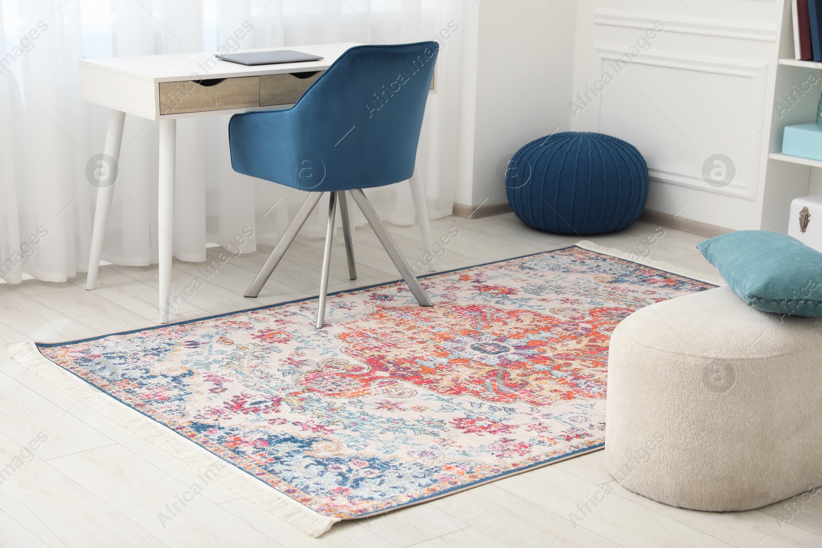 Photo of Stylish rug, armchair and table in room. Interior design