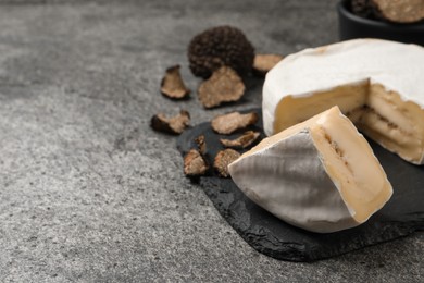 Photo of Delicious truffle cheese on grey table, closeup. Space for text