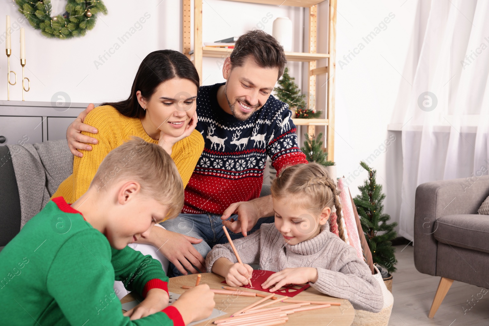 Photo of Cute children with their parents making beautiful Christmas greeting cards at home