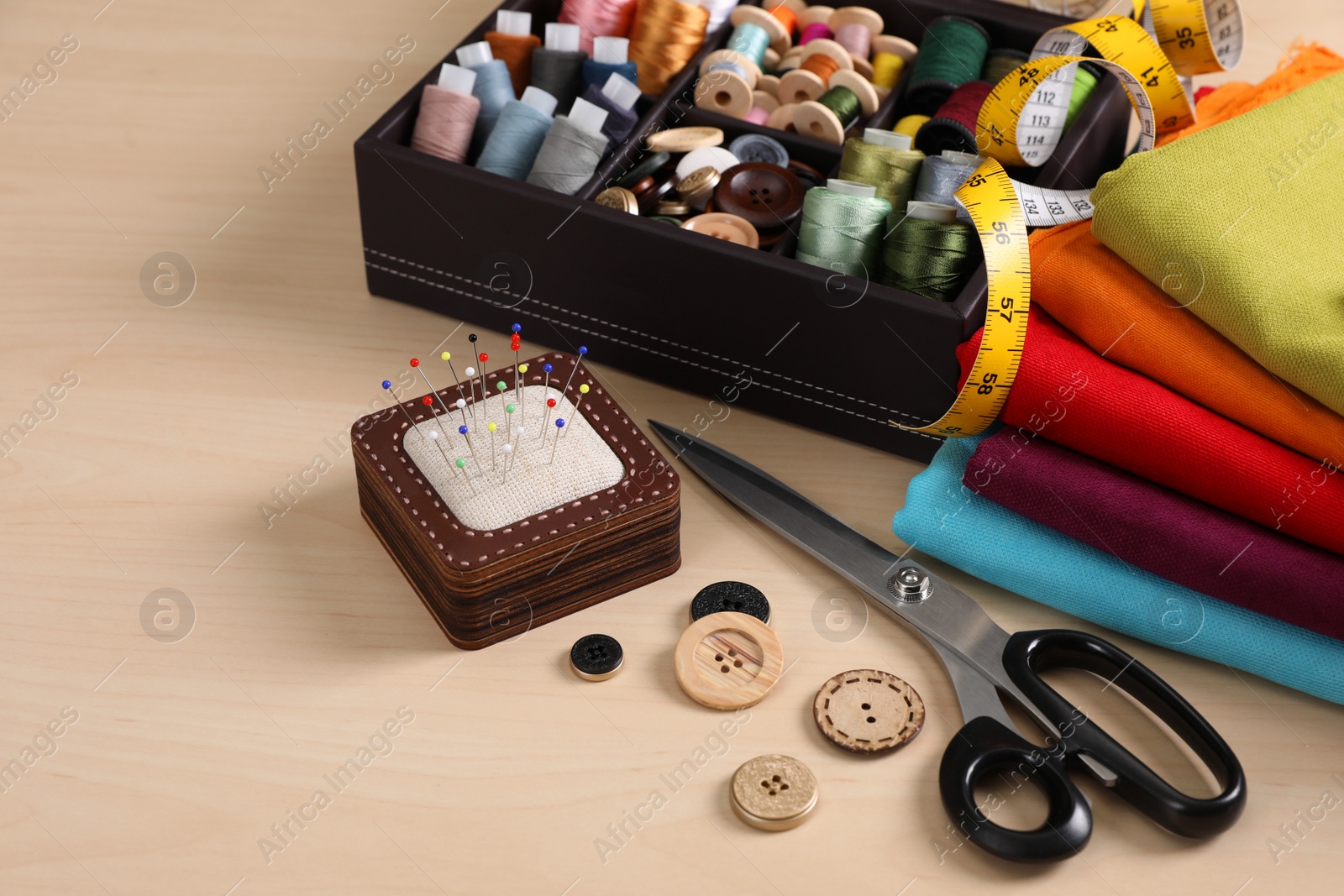 Photo of Set of sewing supplies and accessories on wooden table