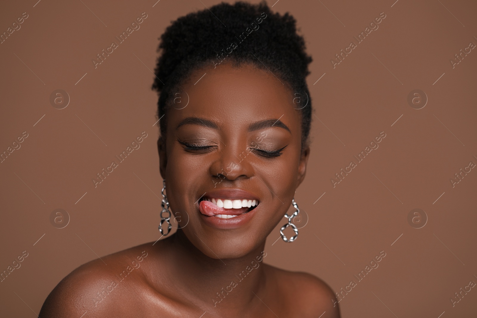 Photo of Fashionable portrait of beautiful happy woman on light brown background