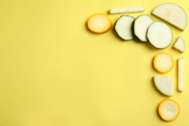 Photo of Fresh ripe cut zucchinis on yellow background, flat lay. Space for text