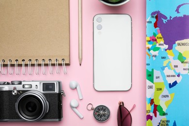 Photo of Flat lay composition with modern smartphone and travel items on pink background