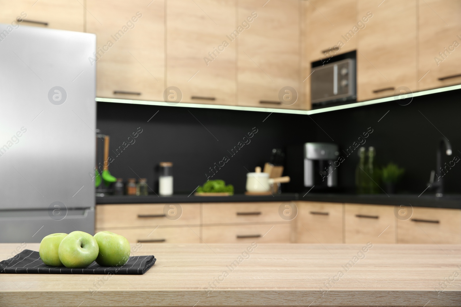 Photo of Fresh apples on table in kitchen, selective focus