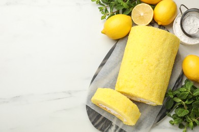 Photo of Delicious cake roll, lemons, mint and powdered sugar on white marble table, flat lay. Space for text