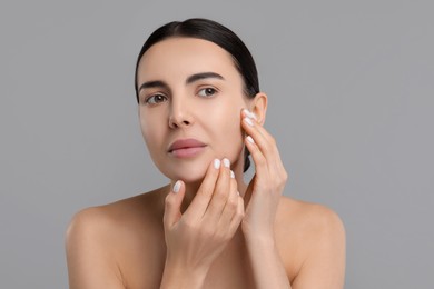 Photo of Young woman with dry skin on gray background