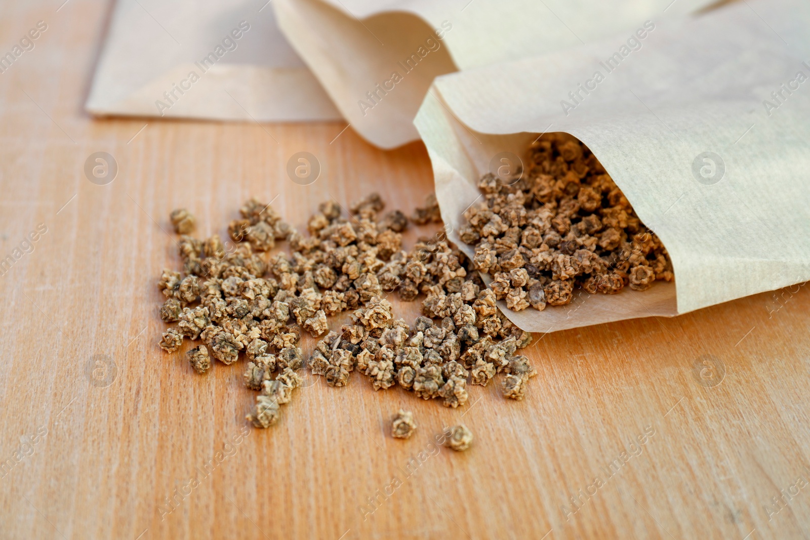 Photo of Paper bags with beet seeds on wooden table, closeup. Vegetable planting