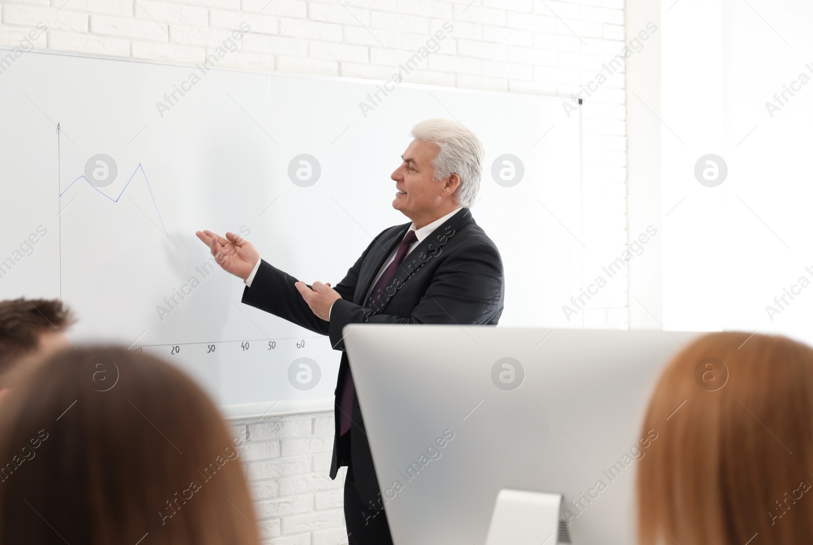 Photo of Senior business trainer working with people in office