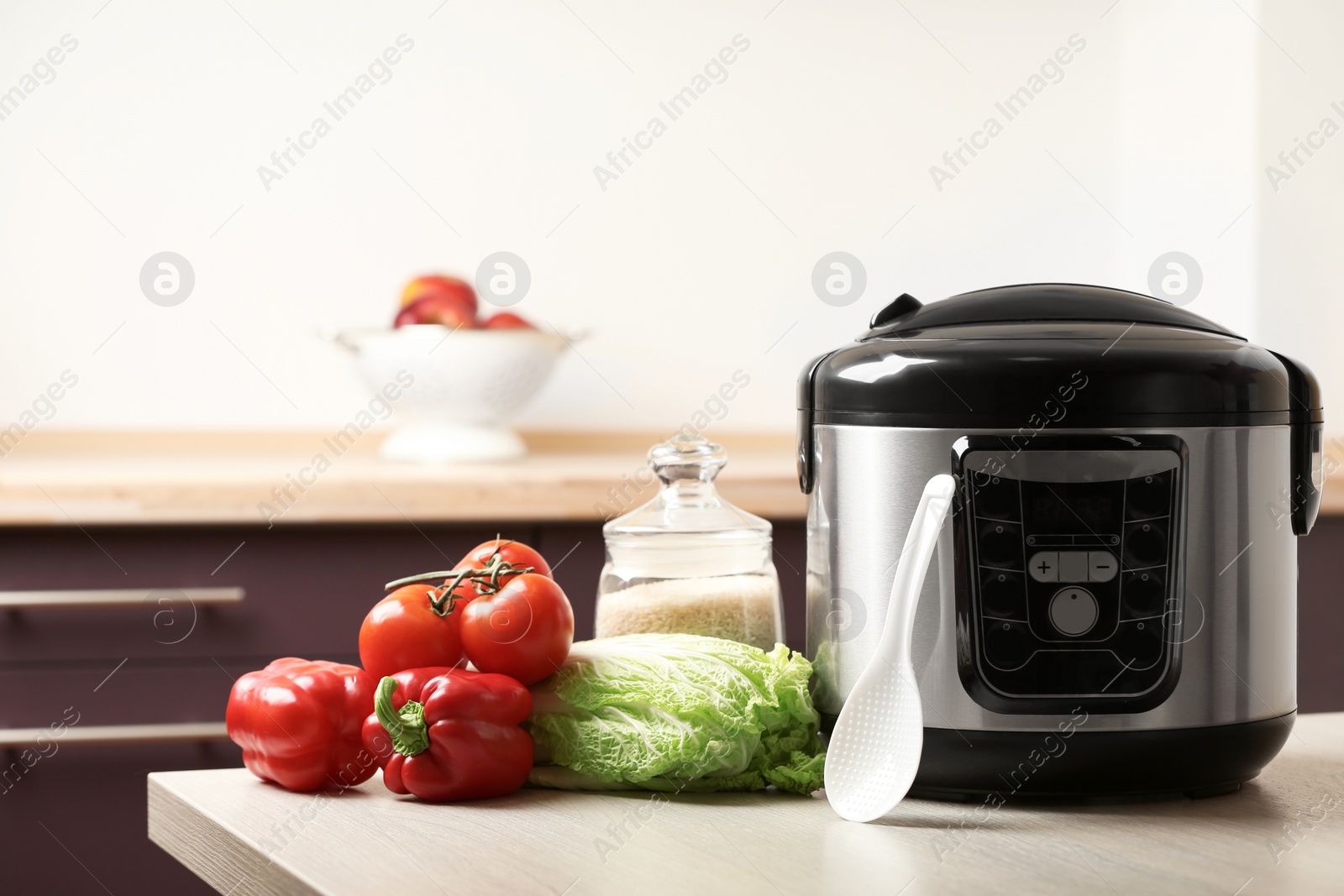 Photo of Modern multi cooker and products on table in kitchen. Space for text