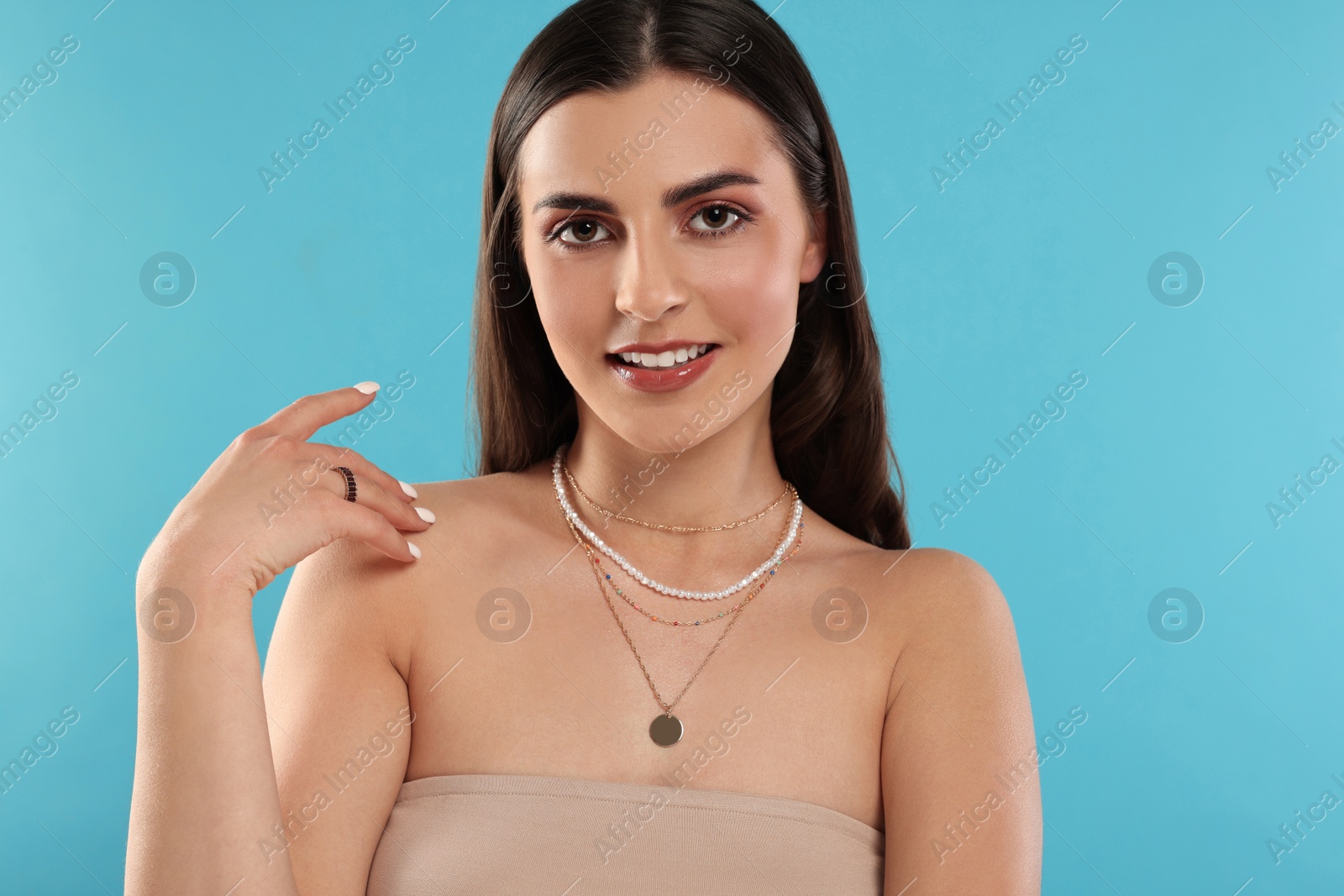 Photo of Beautiful woman with elegant jewelry on light blue background