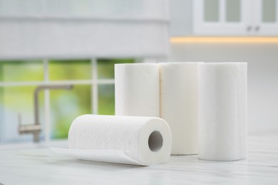 Photo of Many rolls of paper towels on white marble table in kitchen