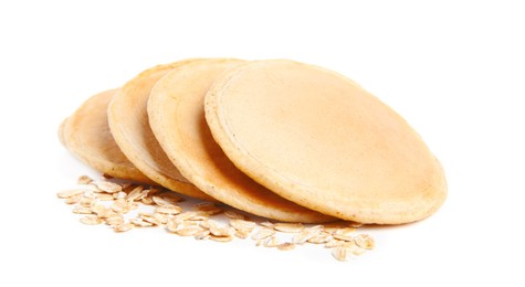 Tasty oatmeal pancakes and flakes on white background