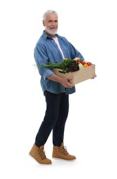 Photo of Harvesting season. Happy farmer holding wooden crate with vegetables on white background