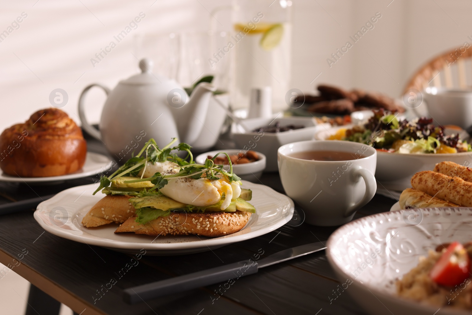 Photo of Delicious sandwiches with eggs and avocado served on buffet table for brunch