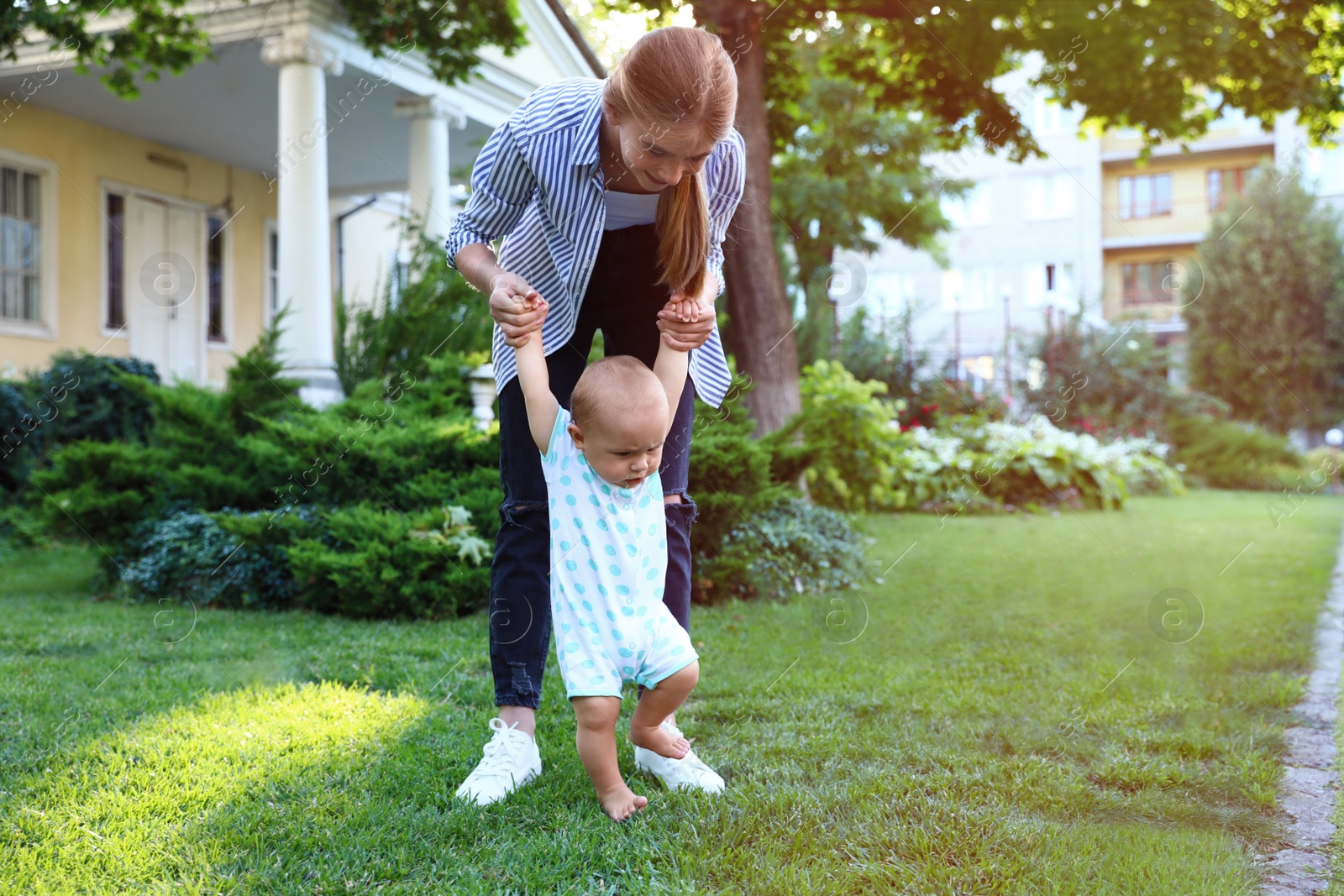 Photo of Teen nanny with cute baby on green grass outdoors