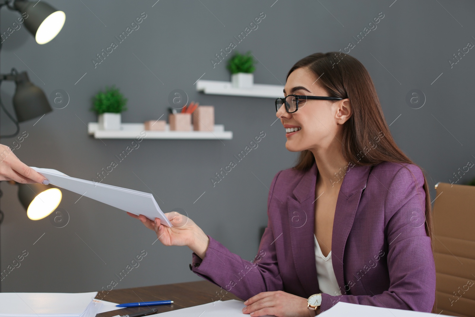 Photo of Businesswoman taking documents from co-worker in office