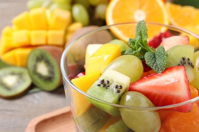 Delicious fresh fruit salad in dish on table, closeup view