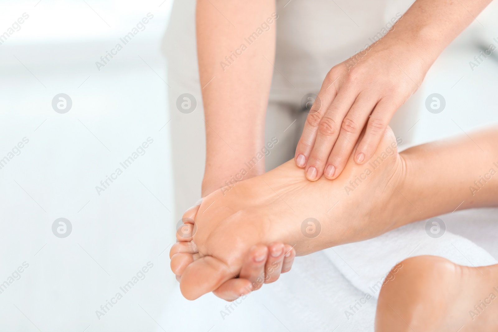 Photo of Woman receiving foot massage in wellness center, closeup