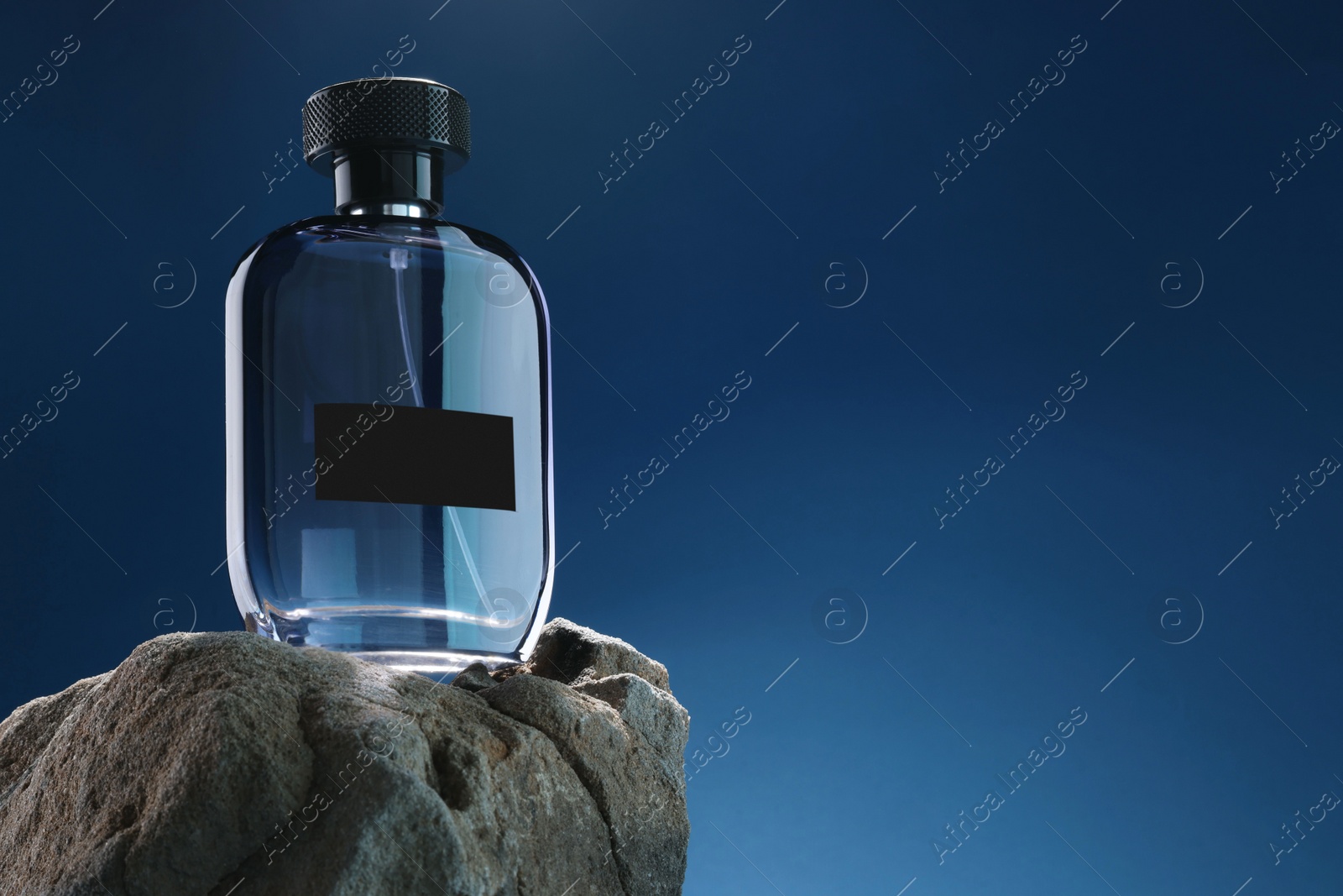 Photo of Stylish presentation of luxury men`s perfume on stone against light blue background. Space for text