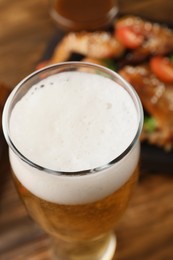 Glass of fresh beer on table, closeup view