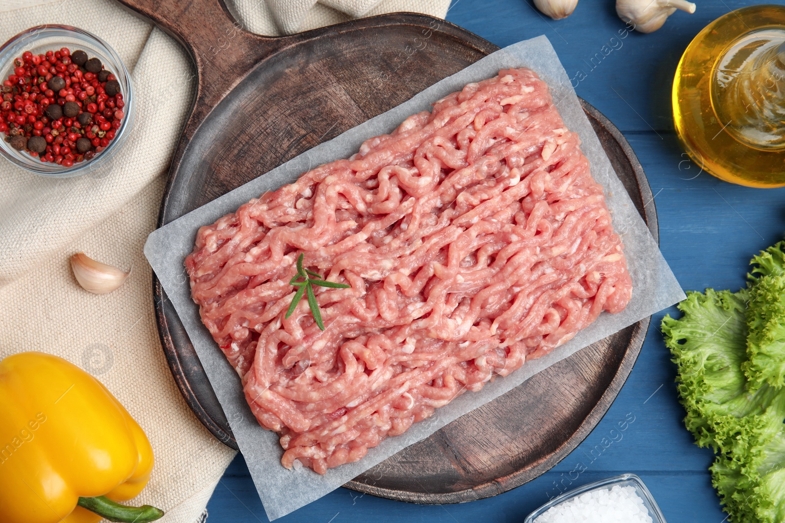 Photo of Raw chicken minced meat and ingredients on blue wooden table, flat lay