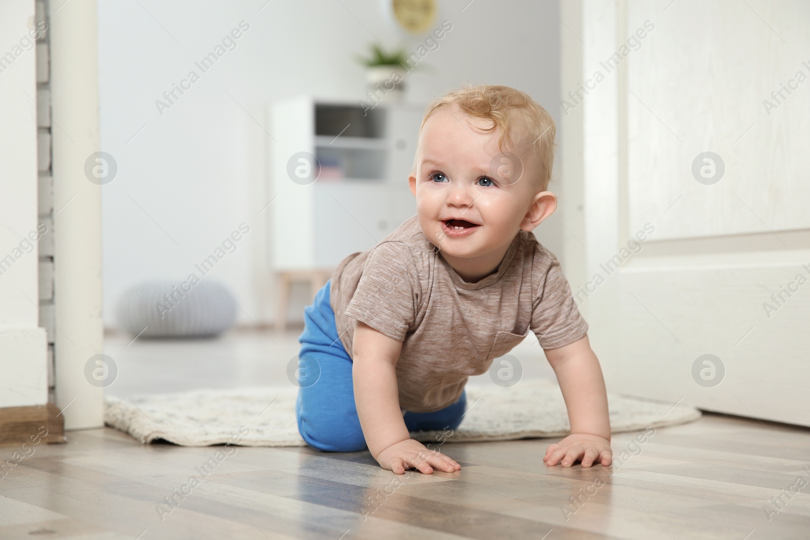 Photo of Cute little baby crawling on floor indoors