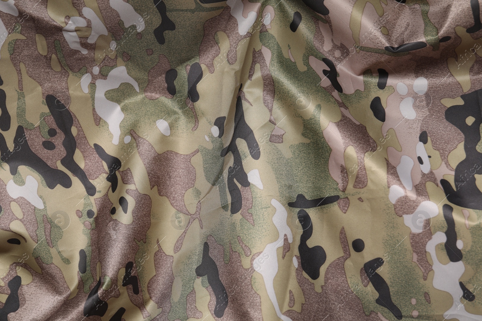 Photo of Texture of crumpled camouflage fabric as background, top view