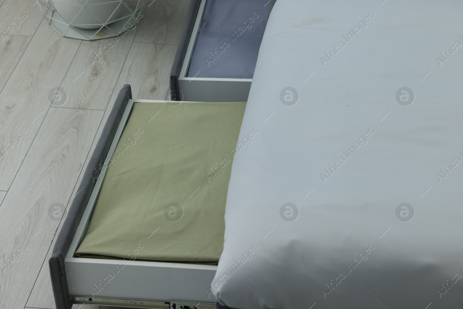 Photo of Storage drawers with bedding under modern bed in room