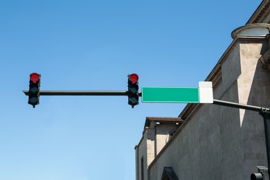 Photo of Traffic lights against blue sky. Road rules