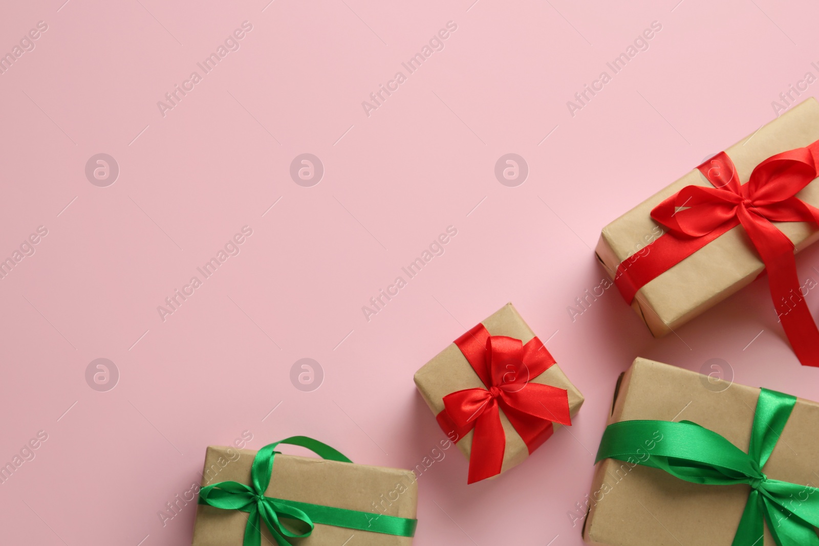 Photo of Bright gift boxes on pink background, flat lay. Space for text