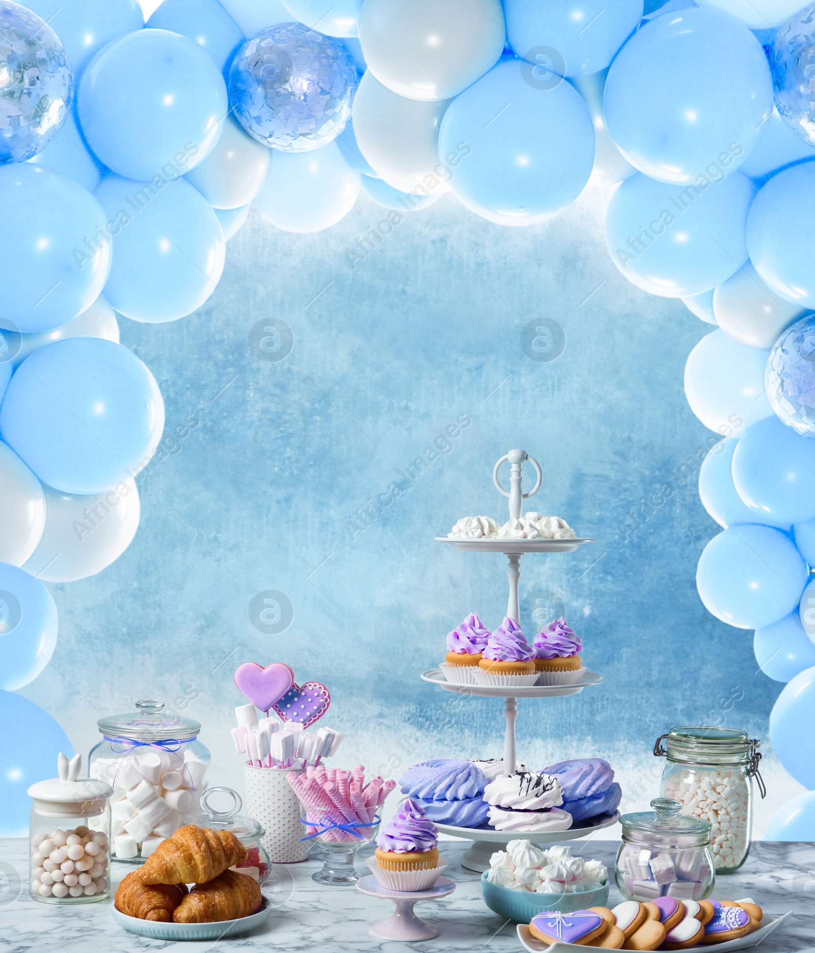 Image of Baby shower party for boy. Tasty treats on table in room decorated with balloons