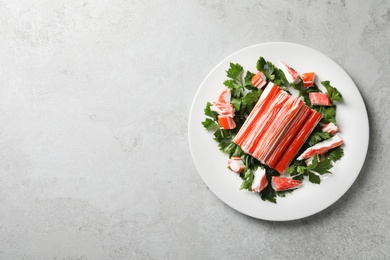 Photo of Crab sticks and parsley on light table, top view. Space for text