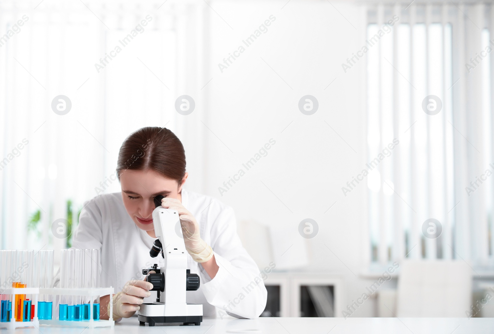 Photo of Scientist using modern microscope at table. Medical research