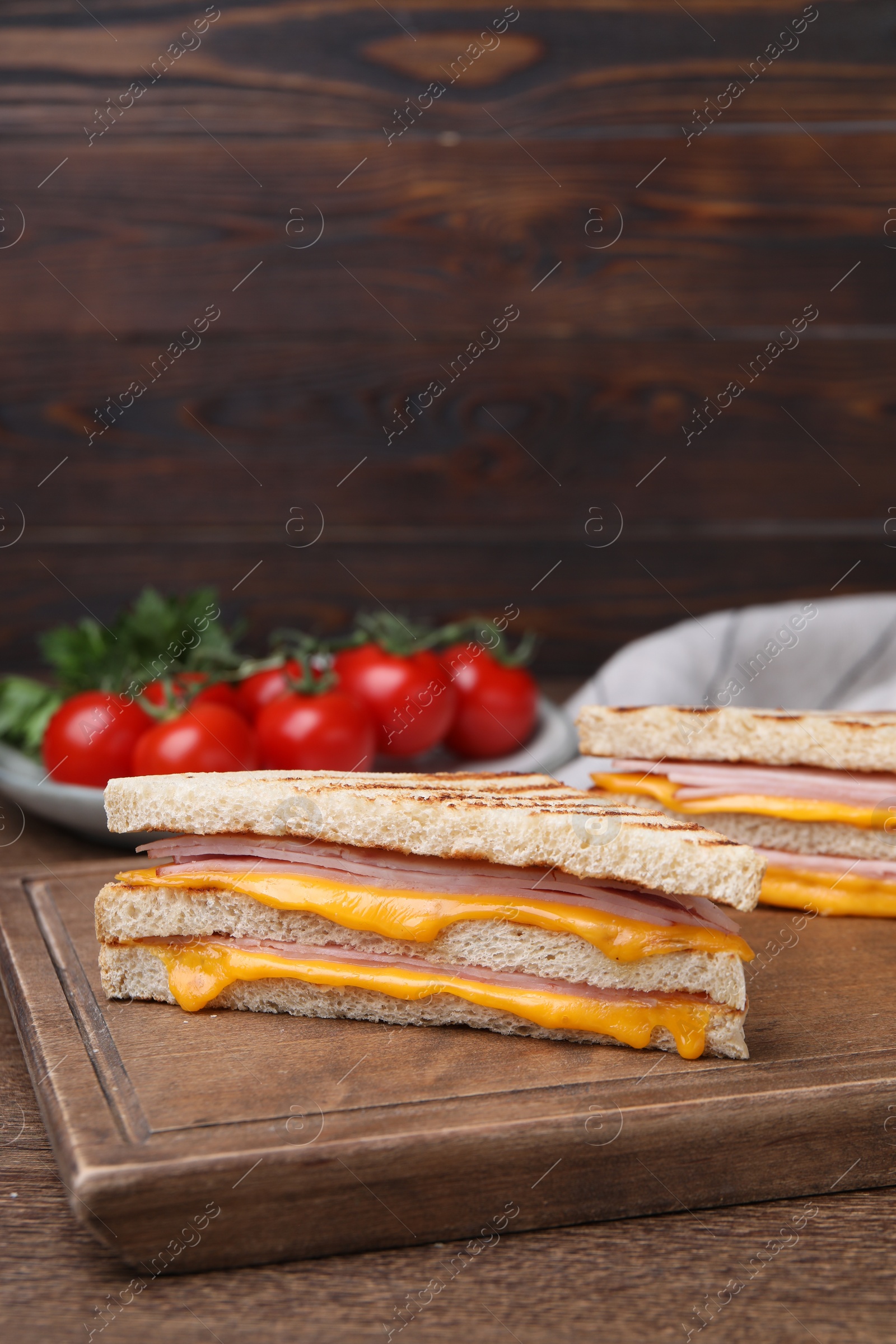 Delicious grilled sandwiches with ham and cheese on wooden table Photo of Delicious grilled sandwiches with ham and cheese on wooden table
