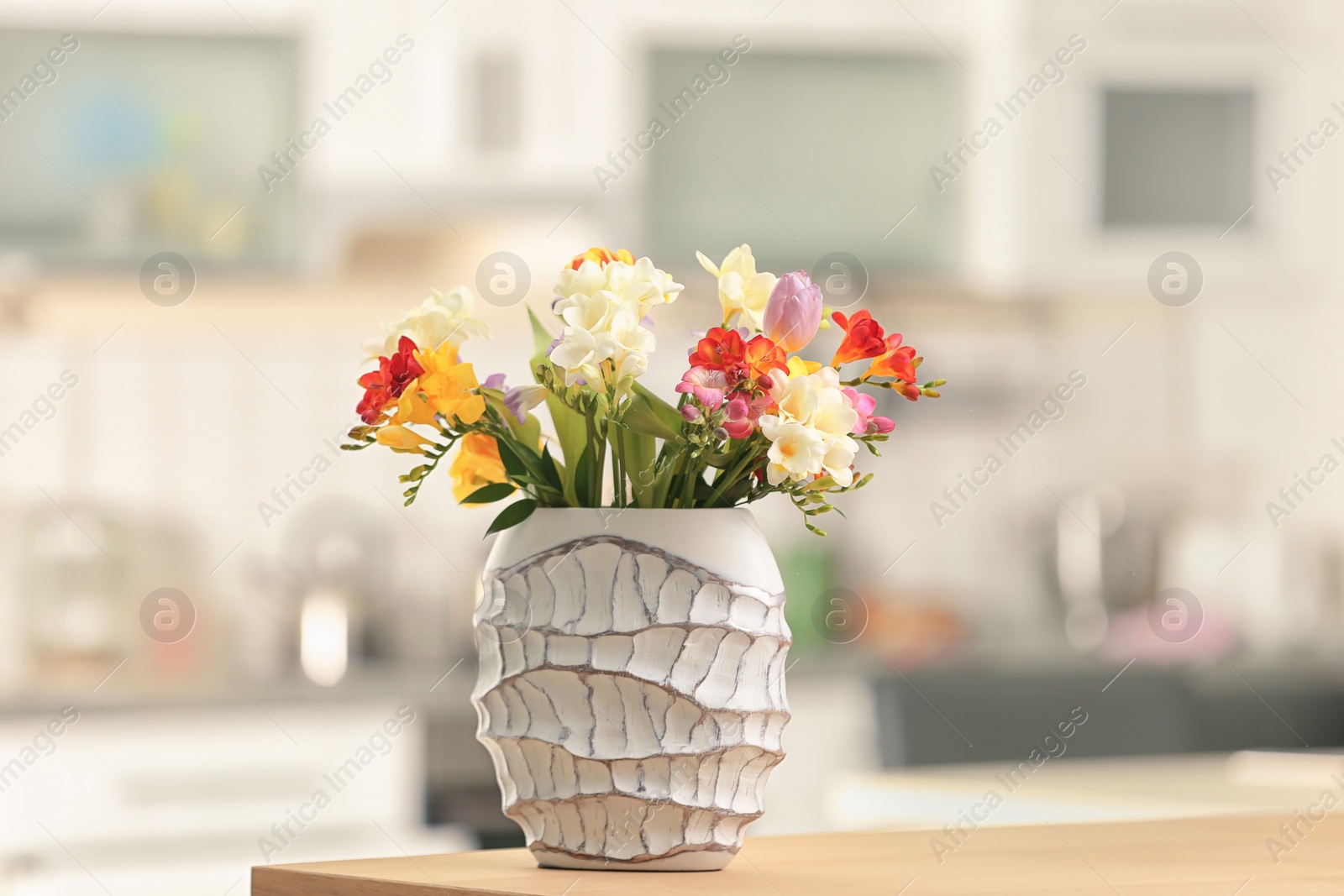 Photo of Beautiful bouquet of freesia flowers indoors