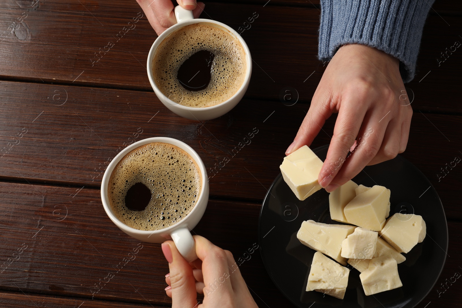 Photo of Women having coffee break at wooden table, above view