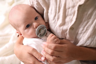 Photo of Mother hugging cute newborn baby on bed, closeup