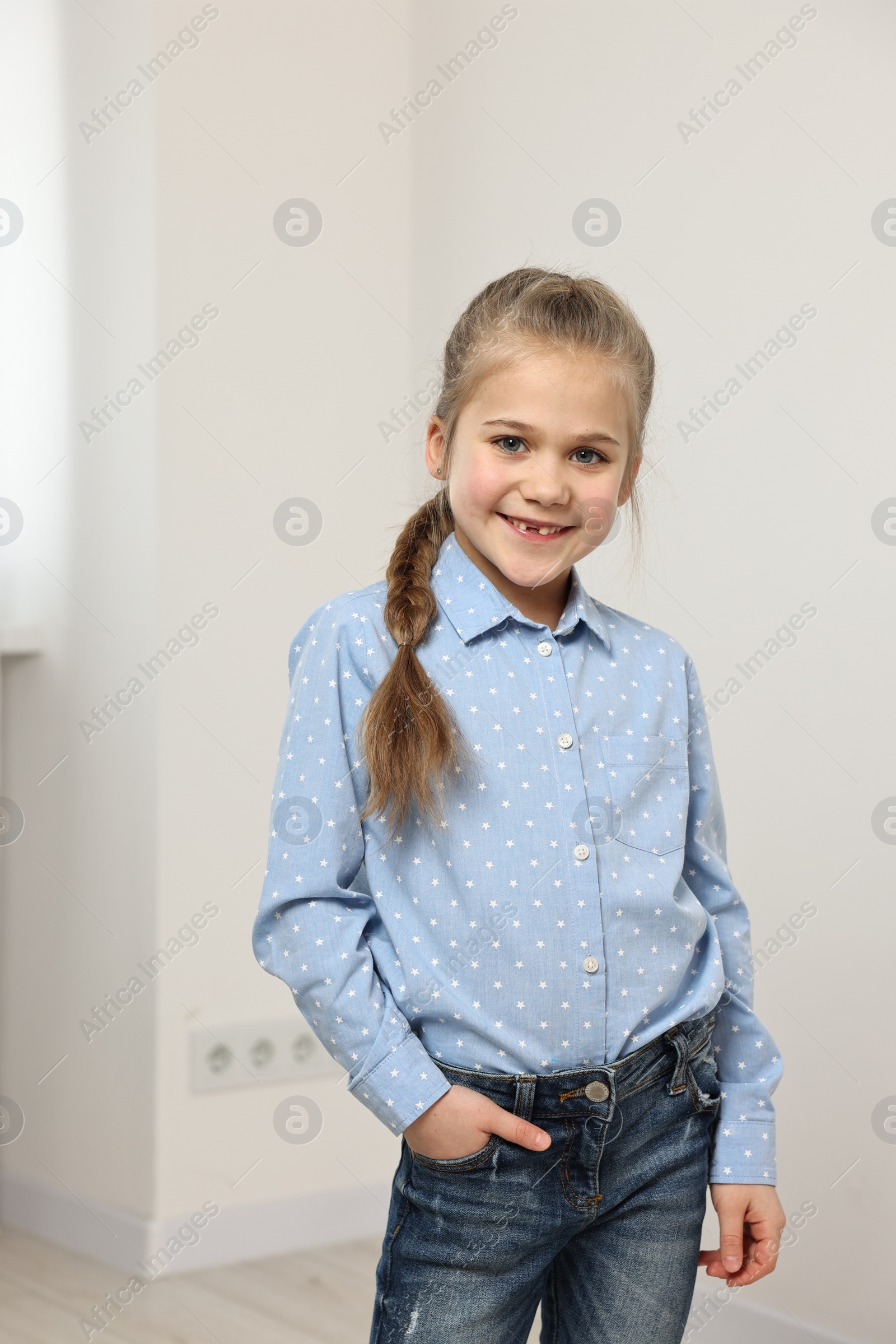 Photo of Cute little girl with braided hair indoors