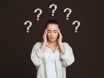 Image of Amnesia. Confused young woman and question marks on brown background