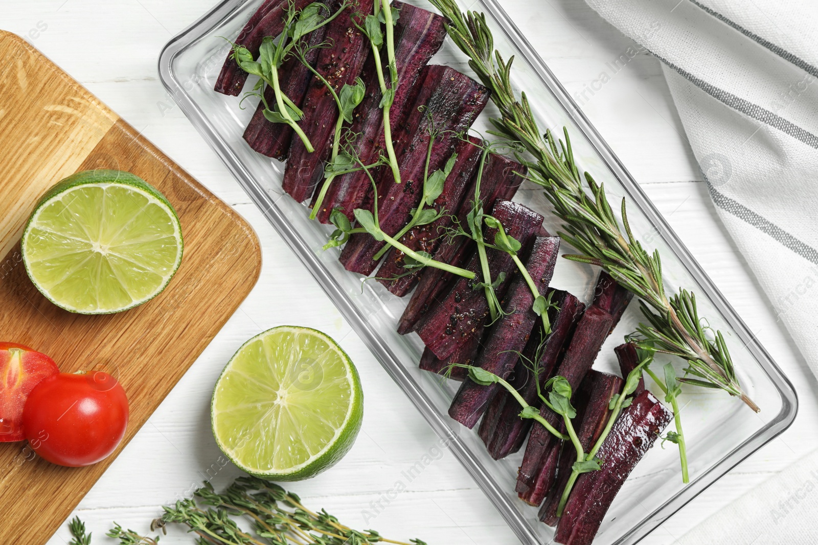 Photo of Flat lay composition with raw black carrot in baking dish on white wooden table