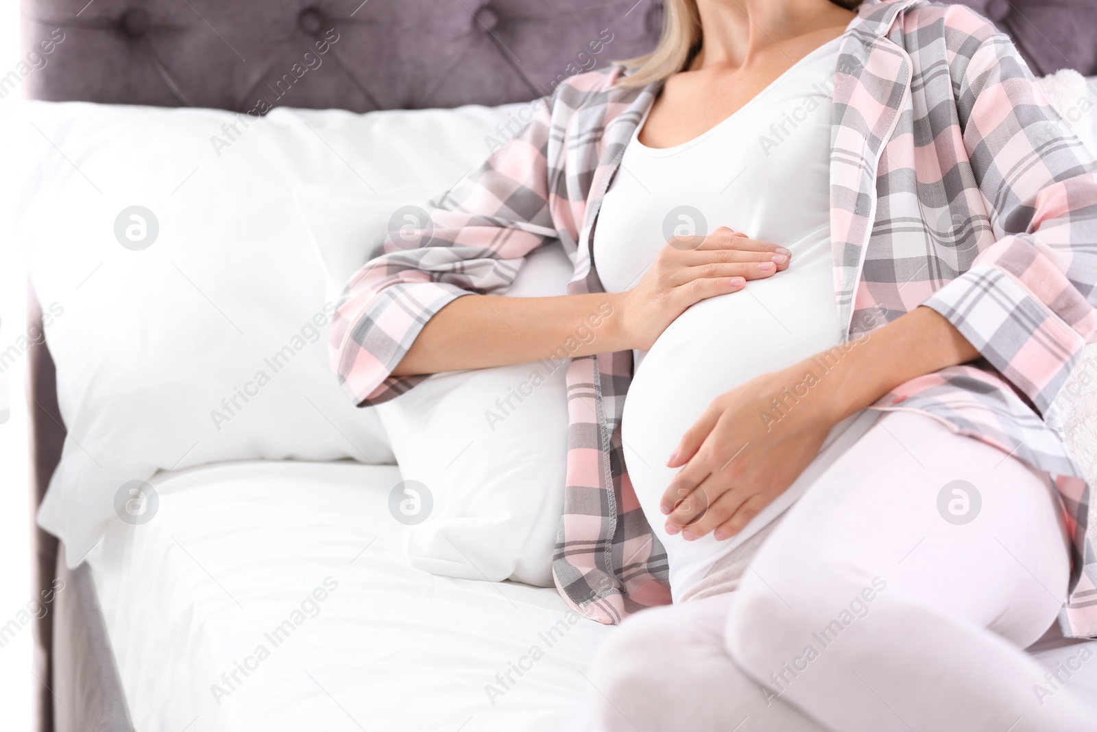 Photo of Happy pregnant woman lying in bed at home, closeup