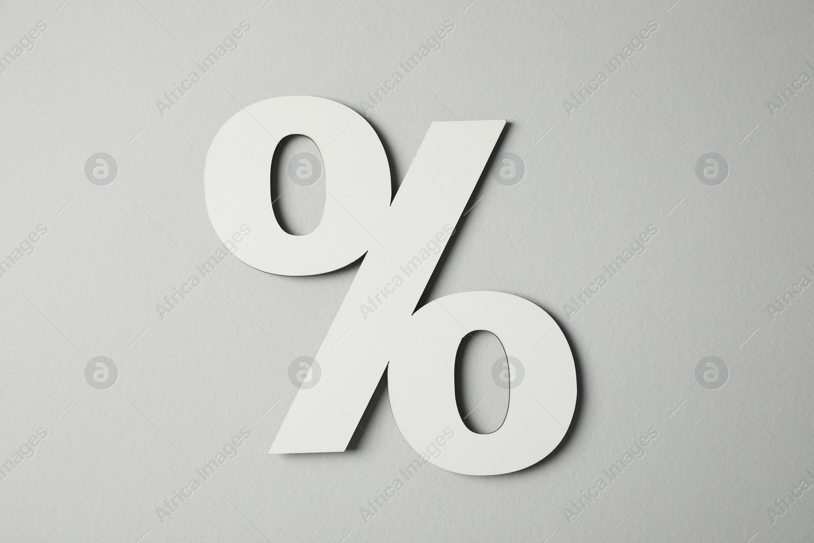 Photo of White percent sign on light grey background, top view