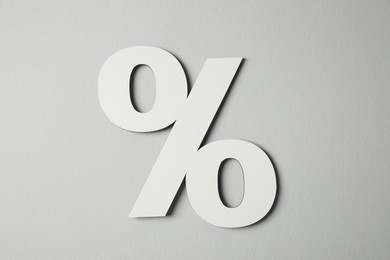 Photo of White percent sign on light grey background, top view