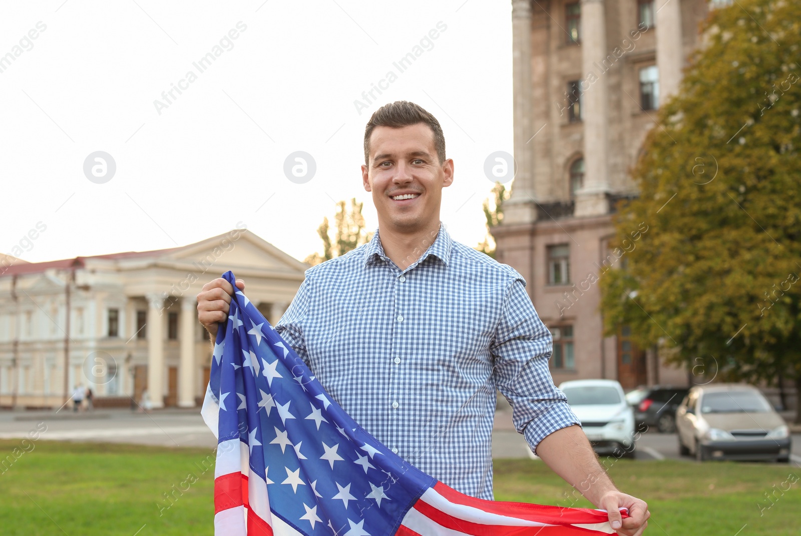 Photo of Man with American flag on city street