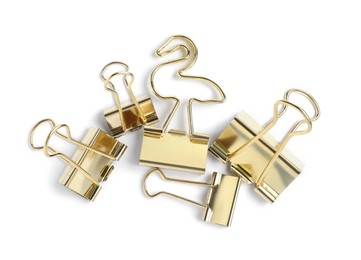 Photo of Golden binder clips on white background, top view. Stationery item